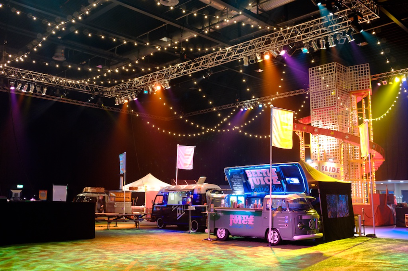 Beetle Juice vans at an indoor event under festoon lighting